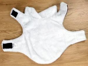 Ein Foto der Romeo Hundejacke im Vintage-Stil in Beige mit einer Rückenlänge von ca. 30 cm aufgemacht und auf den Rücken gelegt