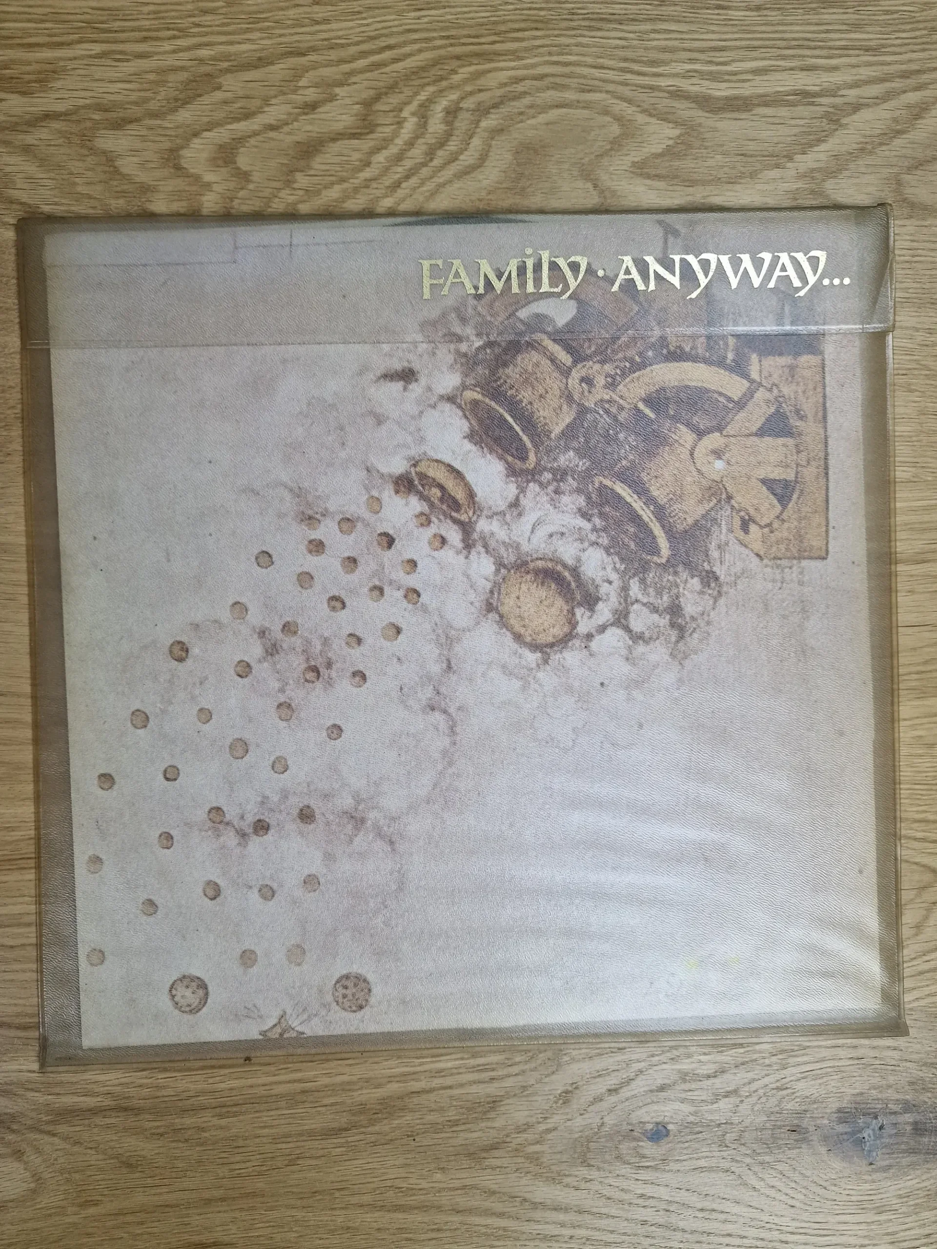 Vorderseite des Vinyl-Albumcovers Family - Anyway... in transparenter Hülle mit goldener Schrift