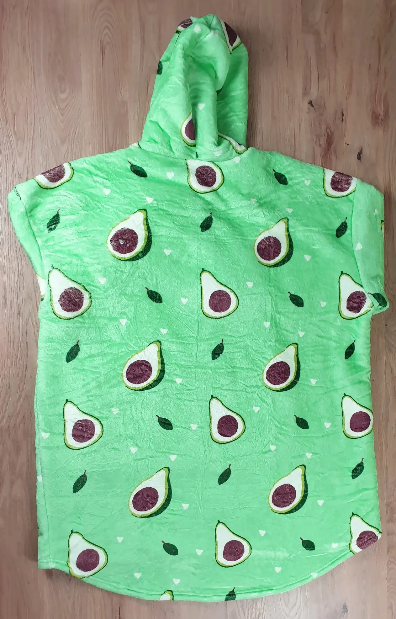 Ein Photo des Decken-Hoodies im Avocado-Design auf den Tisch gelegt mit der Rückenseite zur Kamera