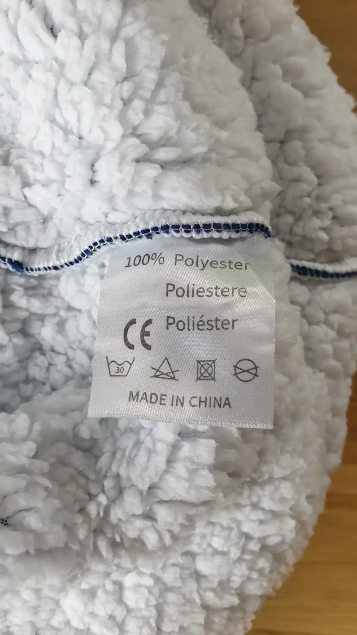 Ein Photo vom Waschzettel mit den Anweisungen, wie man die Decken-Hoodies waschen kann und wie man sie beim waschen behandeln sollte