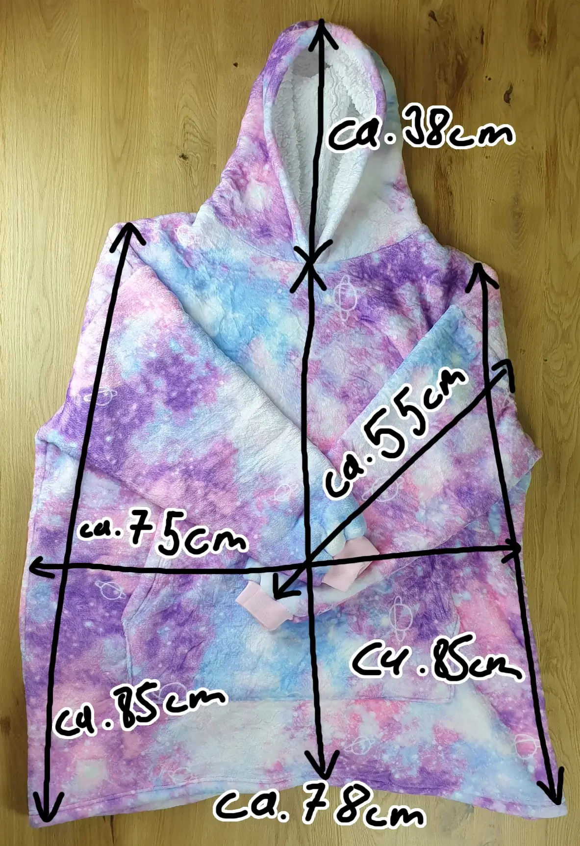 Universum Decken-Hoodie Maße Ein Bild vom Decken-Hoodie im Unisversum-Design auf dem Tischh liegend mit den Maßen des Decken-Hoodies eingezeichnet