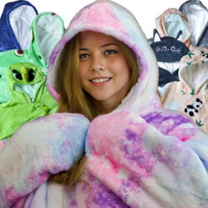 Junge Frau präsentiert verschiedene verfügbare Decken-Hoodies im Universums-Design, mit anderen Hoodies im Hintergrund arrangiert.