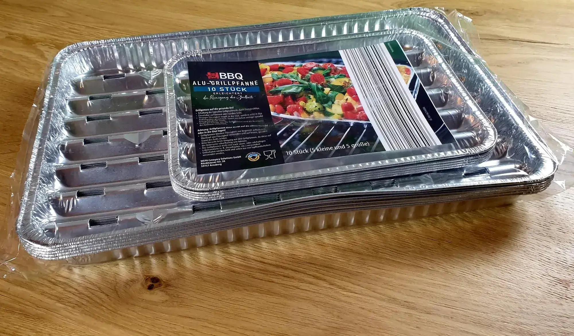 BBQ-Alu-Grillpfanne-10-Stueck_10 10 Stück der BBQ Alu-Grillpfanne aufeinander gestapelt, leicht schräg von vorne fotografiert
