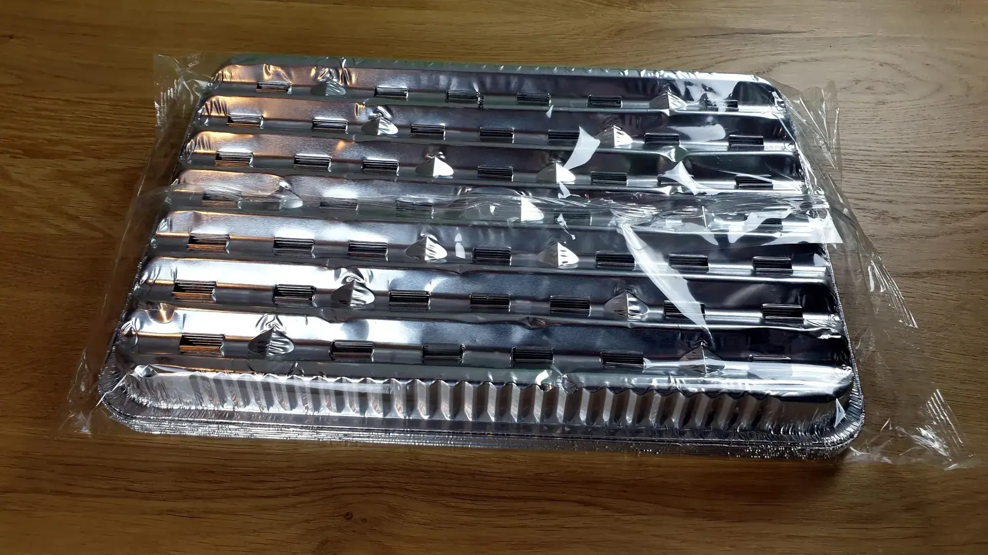 BBQ-Alu-Grillpfanne-10-Stueck_4 Die BBQ Alu-Grillpfanne auf den Kopf gelegt mit 10 Stück aufeinander gestapelt, leicht schräg von oben fotografiert