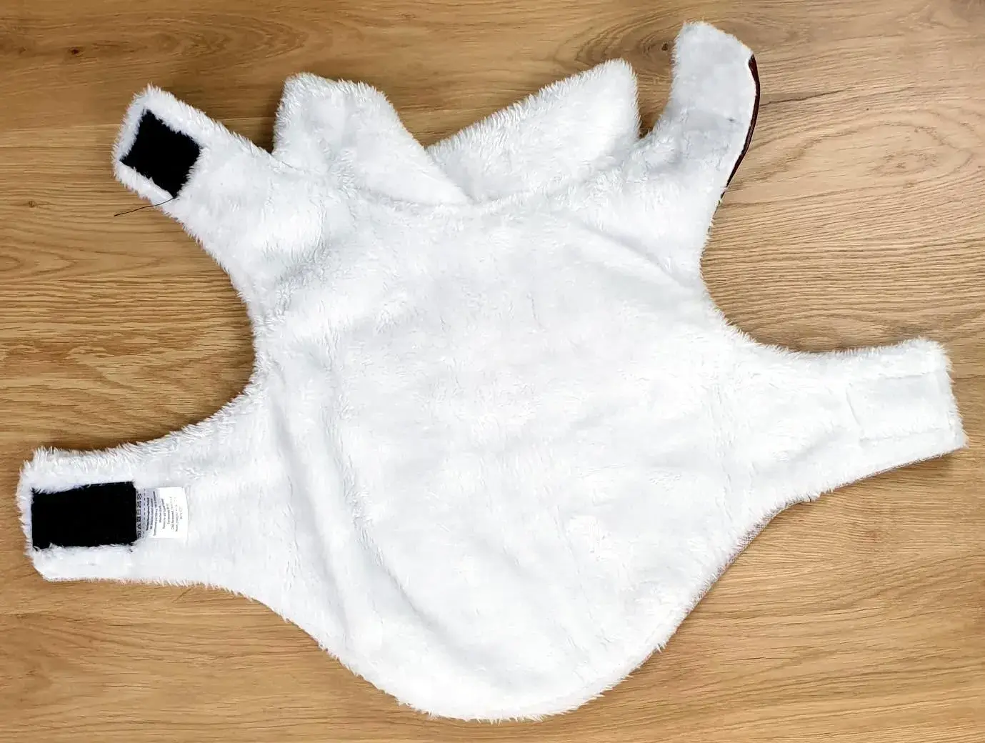 Ein Foto der Romeo Hundejacke im Vintage-Stil in Beige mit einer Rückenlänge von ca. 30 cm aufgemacht und auf den Rücken gelegt