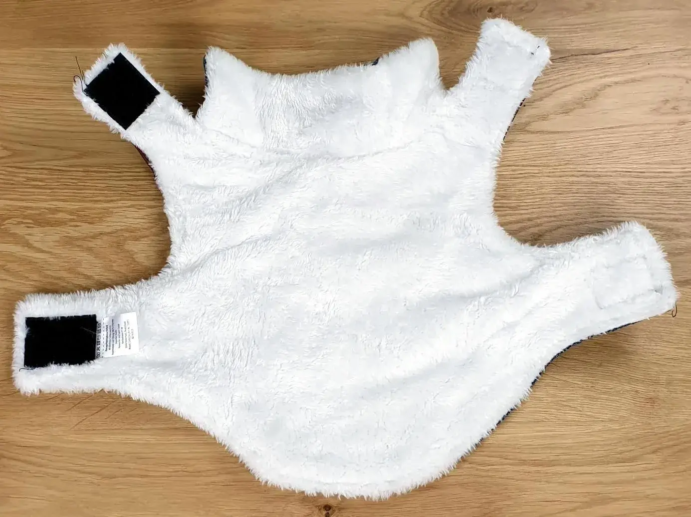 Ein Foto der Romeo Hundejacke im Vintage-Stil in Blau mit einer Rückenlänge von ca. 30 cm aufgemacht und auf den Rücken gelegt