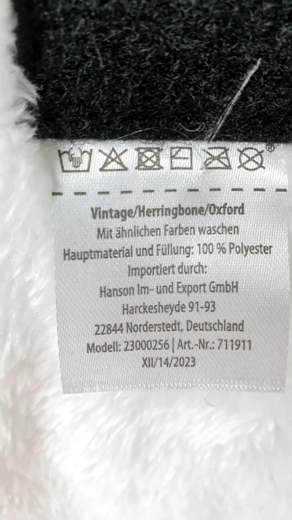 Ein Foto des Waschzettels der Romeo Hundejacke im Vintage-Stil in Blau mit einer Rückenlänge von etwa 30 cm.