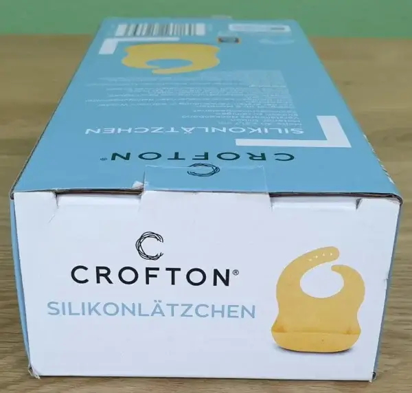 CROFTON Silikonlätzchen in seiner Verpackung von oben.