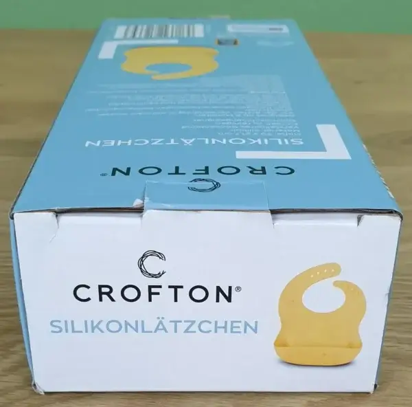 CROFTON Silikonlätzchen in seiner Verpackung von oben.