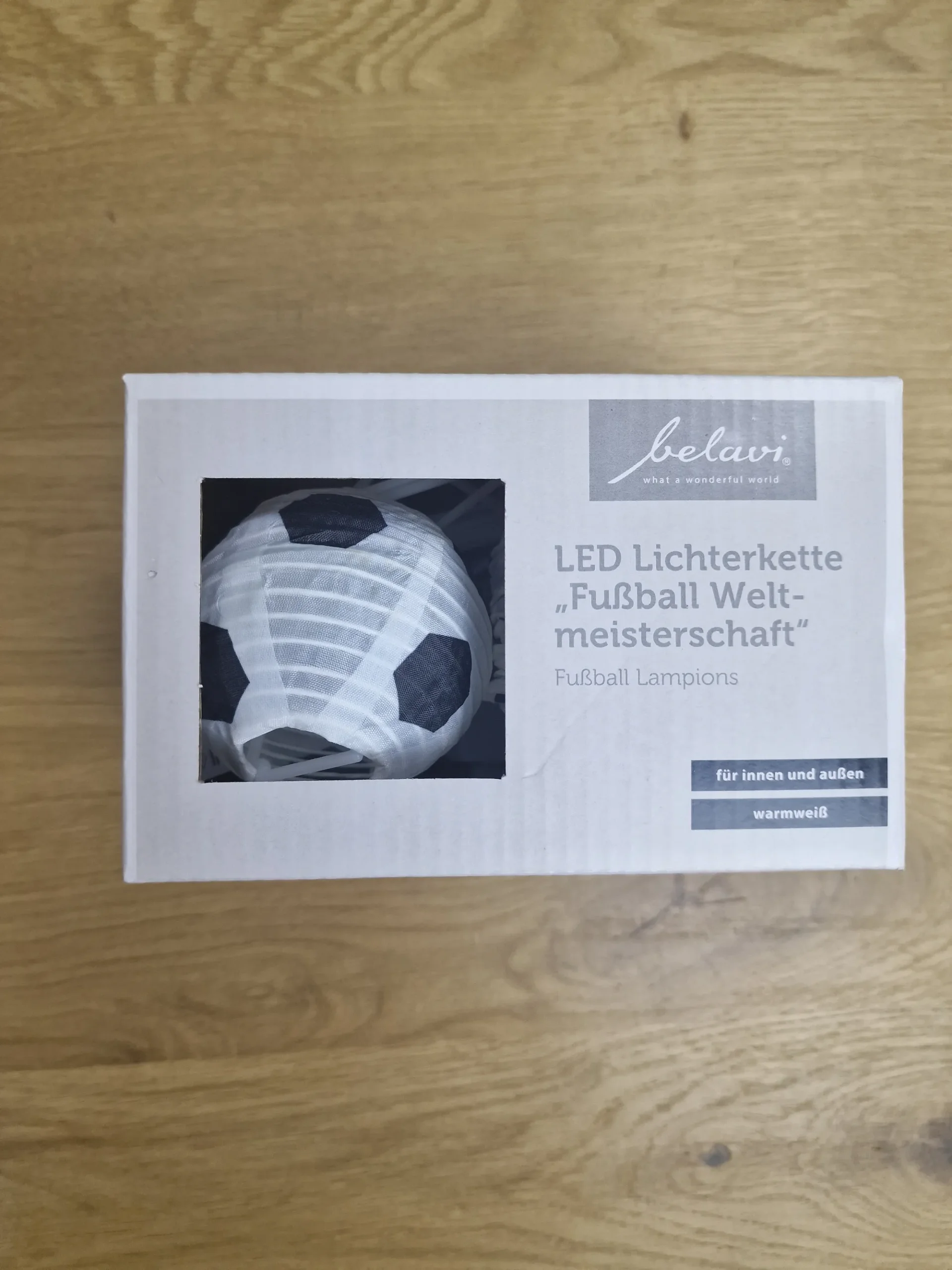 belavi-fussball-lampion-led-lichterkette-sichtfenster Nahaufnahme des gefalteten Stoff-Fußball-Lampions in der Verkaufsverpackung