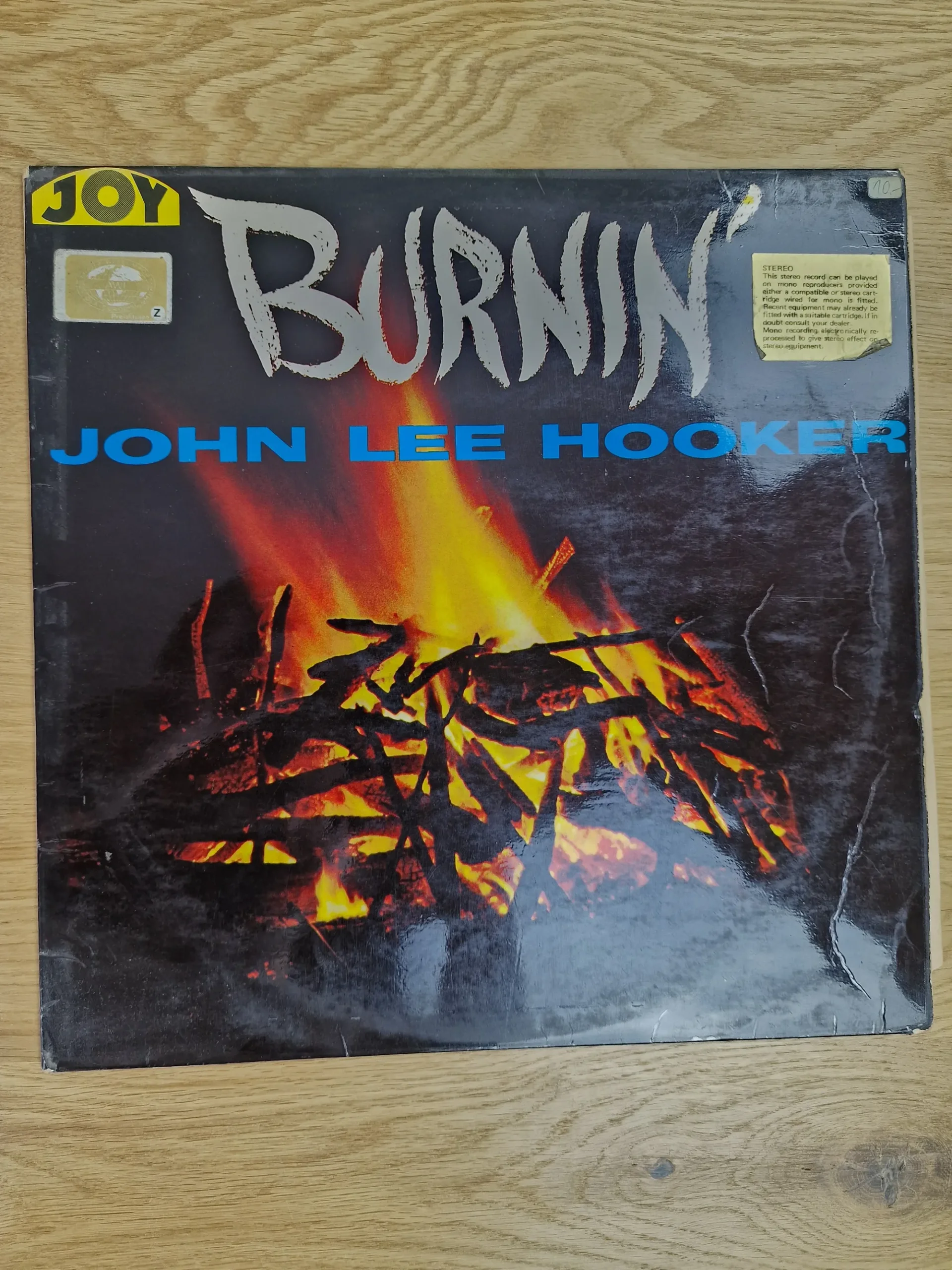 Vorderseite der Vinyl-Schallplatte Burnin' von John Lee Hooker mit Lagerfeuer-Motiv und Joy Records Logo