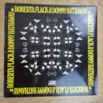 Vorderseite der Vinyl-Schallplatte Roberta Flack & Donny Hathaway mit gelbem Schriftzug und Händemuster