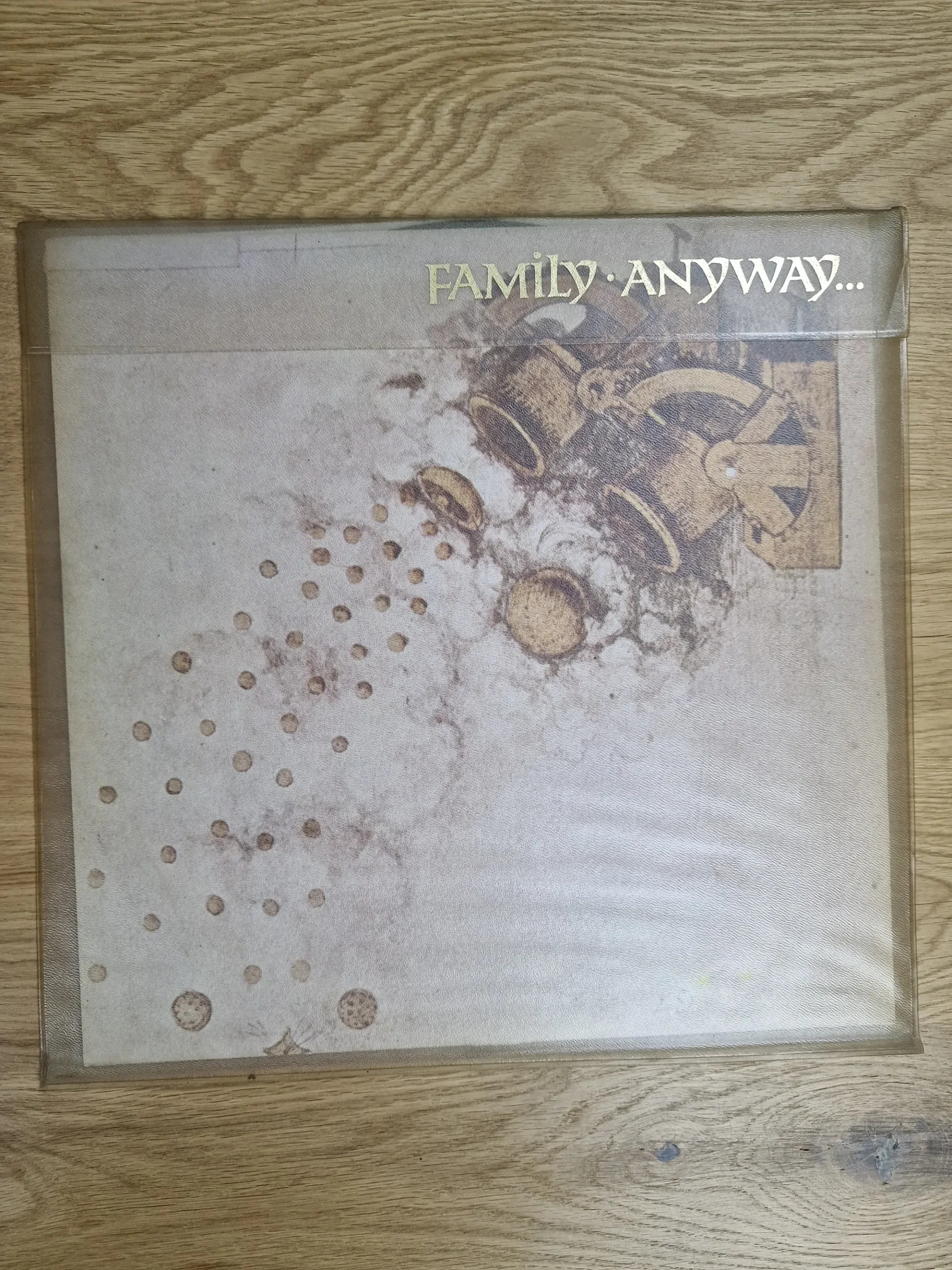 Vorderseite des Vinyl-Albumcovers Family - Anyway... in transparenter Hülle mit goldener Schrift