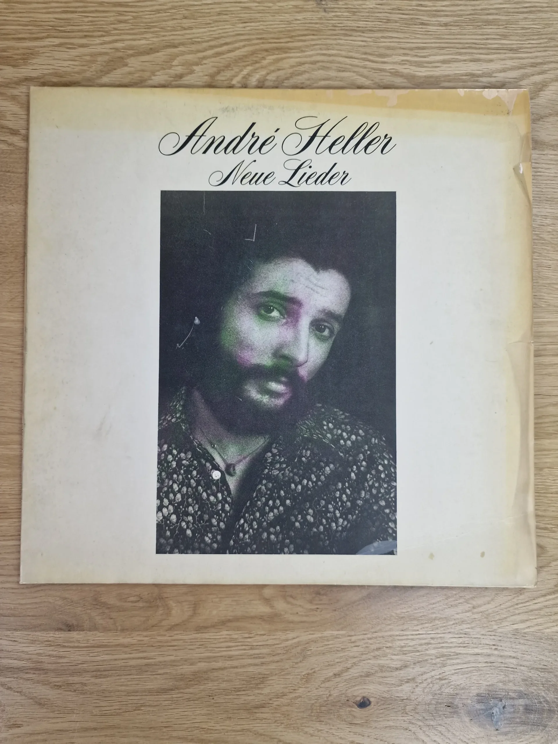 Vorderseite des Vinyl-Album-Covers 'Neue Lieder' von André Heller mit Schwarz-Weiß-Porträt