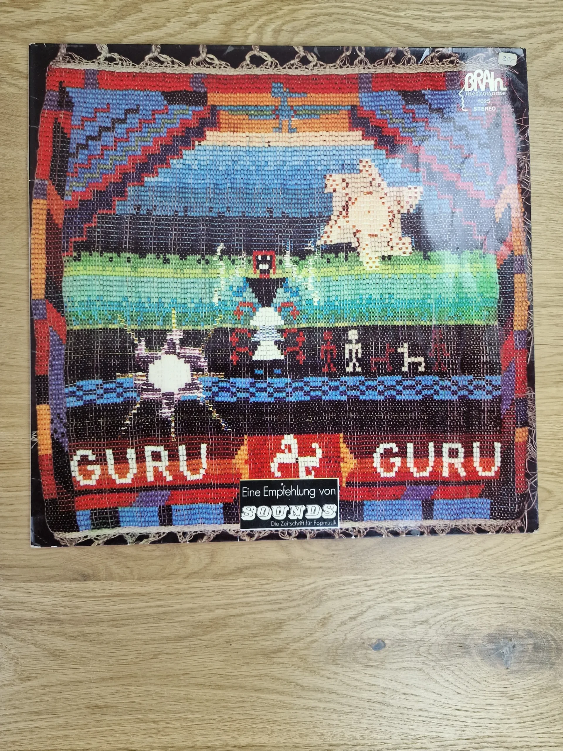 Vorderseite der Guru Guru Vinyl LP Hülle auf Brain Metronome mit Kunsthandwerk-Motiv und SOUNDS Magazin Sticker
