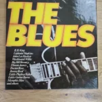 Frontcover der Vinyl-Schallplatte The Blues mit gelb-roter Schrift und Gitarrenmotiv