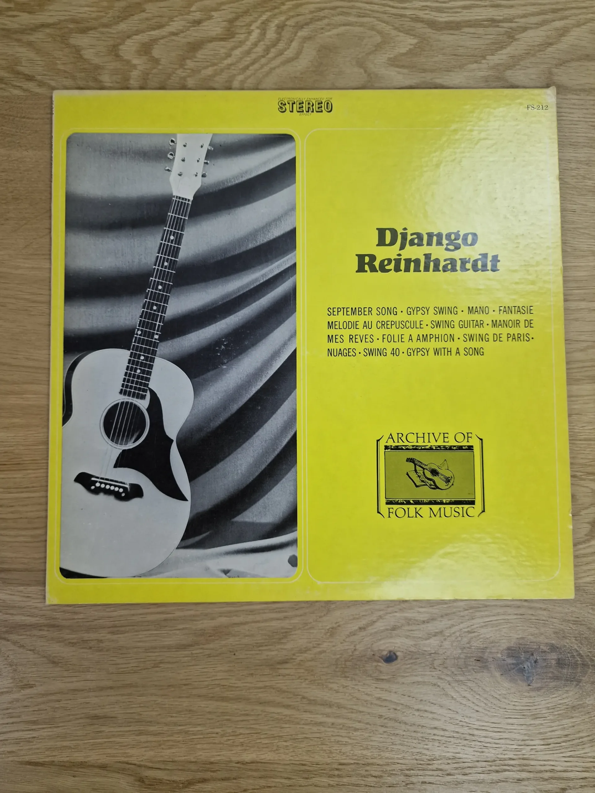 Vorderseite der Django Reinhardt Vinyl-Schallplatte Archive of Folk Music in Gelb mit Gitarre